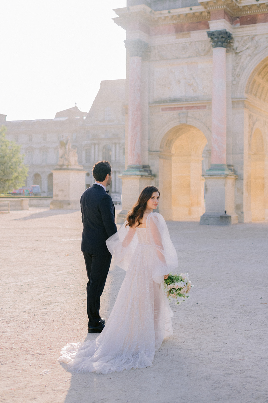 Couple walking in front of the Louvre Pyramid